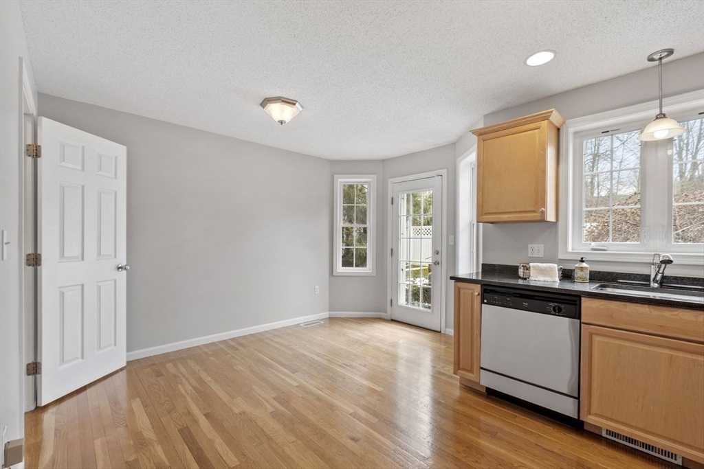 181 High Street, Unit 2 Andover, MA 01810 - Photo 4 of 32 a kitchen with granite countertop a stove a sink and wooden floor