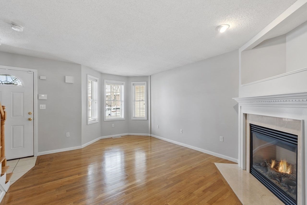 181 High Street, Unit 2 Andover, MA 01810 - Photo 6 of 32 a view of empty room with wooden floor and fireplace