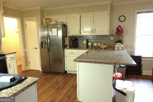 a kitchen with granite countertop a refrigerator a stove and a sink