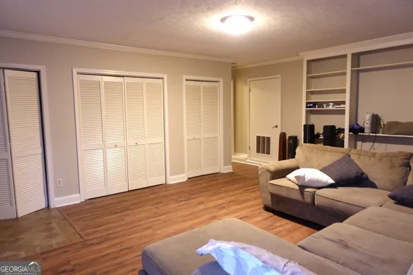 a living room with furniture wooden floor and lamp