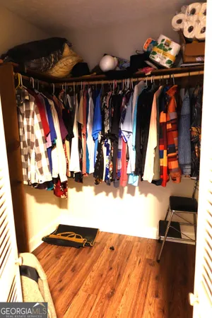 a view of walk in closet with clothes and shoes