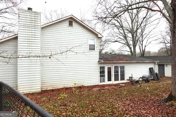 a view of house with backyard and tree