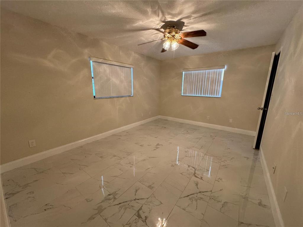 8725 Aruba Lane Port Richey, FL 34668 - Photo 15 of 31 en view of an empty room with a chandelier fan