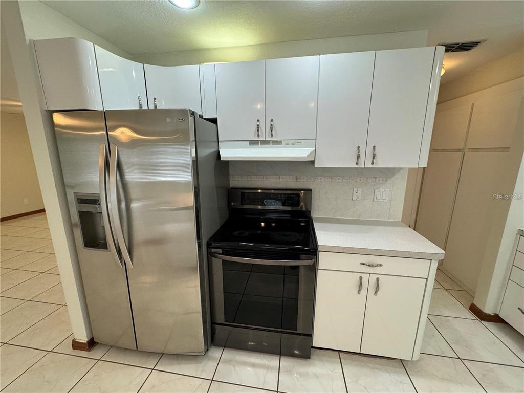8725 Aruba Lane Port Richey, FL 34668 - Photo 24 of 31 a kitchen with a stove top oven and refrigerator