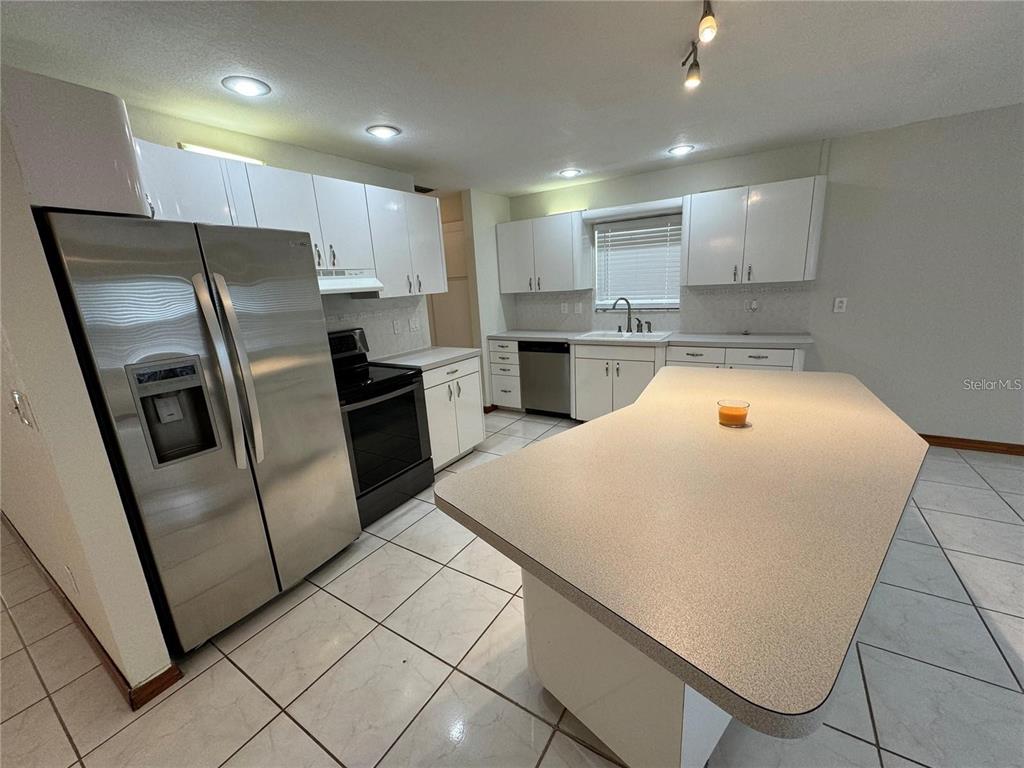 8725 Aruba Lane Port Richey, FL 34668 - Photo 25 of 31 a kitchen with refrigerator and microwave