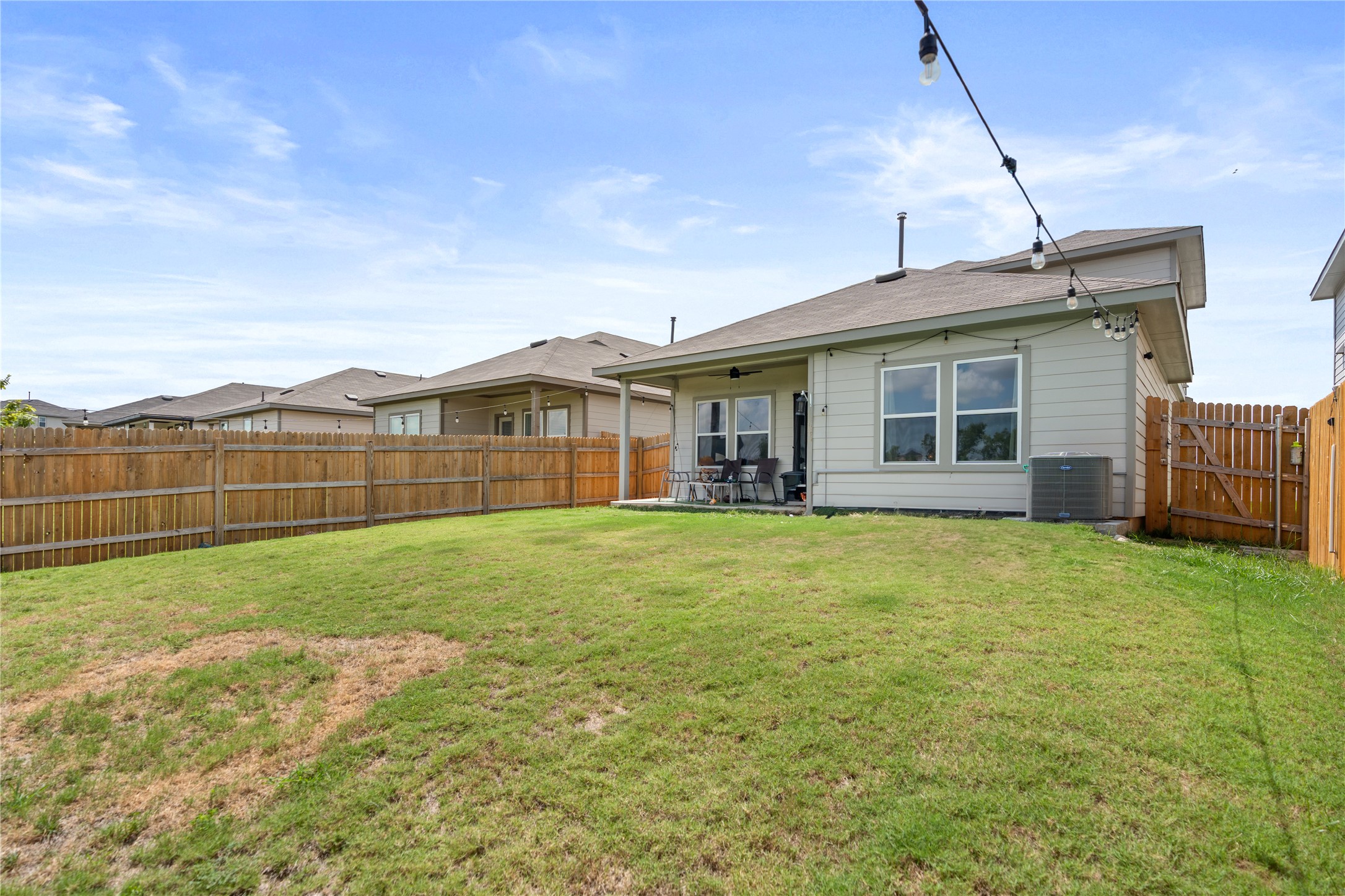 143 Santa Rosa Lane Buda, TX 78610 - Photo 28 of 28 Rear view of house featuring a ceiling fan, a fenced backyard, and a patio area