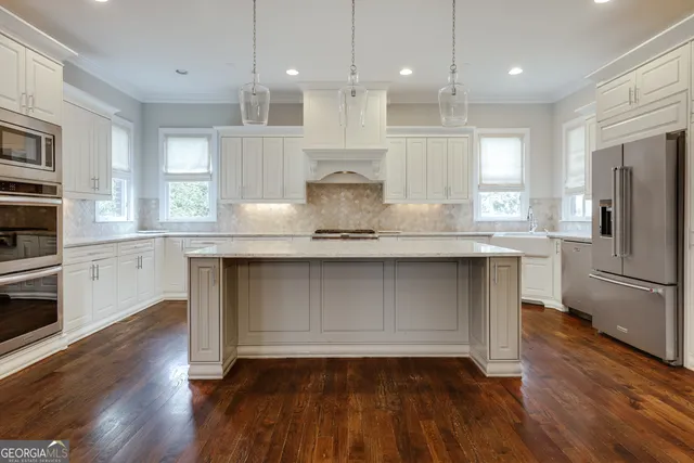 a view of an empty room with wooden floor fireplace and a window