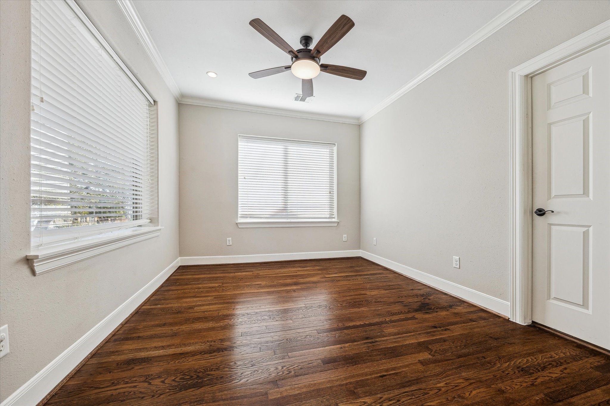 2618 Cleburne Street Houston, TX 77004 - Photo 12 of 25 an empty room with wooden floor chandelier fan and windows