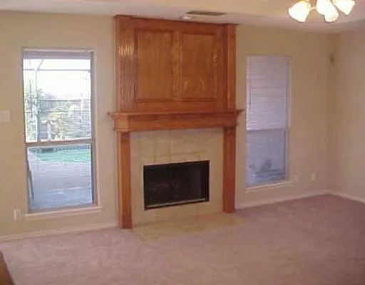 a view of empty room with fireplace and window
