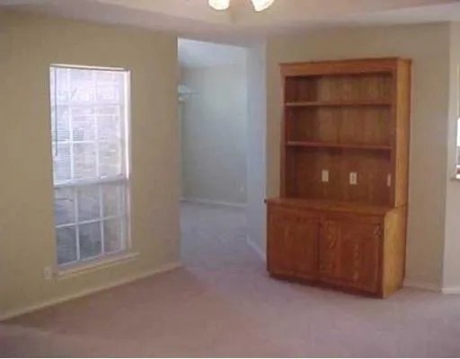 an empty room with windows and cabinet