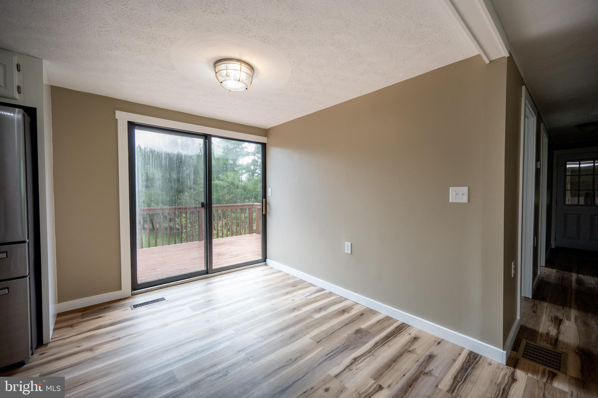 2571 Shady Dell Road Oakland, MD 21550 - Photo 11 of 60 a view of an empty room with wooden floor and a window