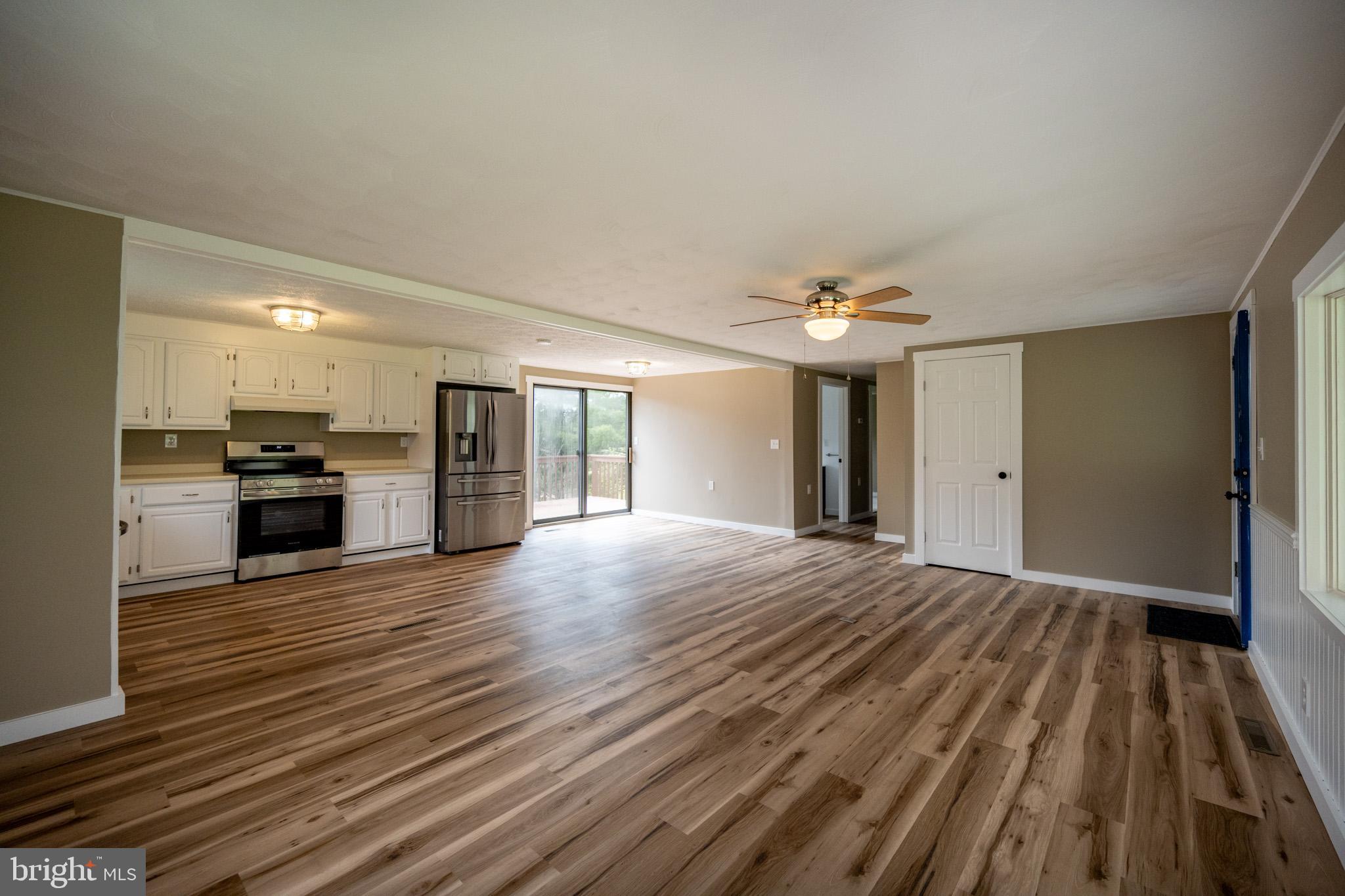 2571 Shady Dell Road Oakland, MD 21550 - Photo 6 of 60 a view of an empty room with wooden floor and a kitchen