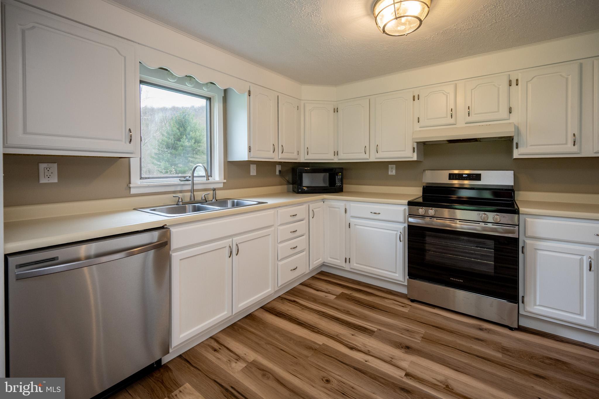 2571 Shady Dell Road Oakland, MD 21550 - Photo 8 of 60 a kitchen with cabinets appliances a sink and a window