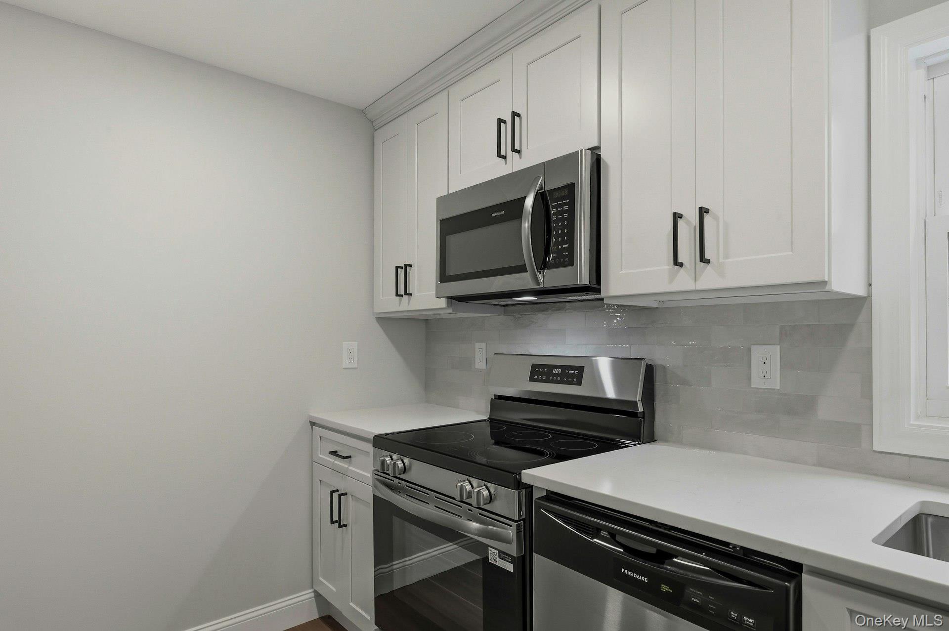 101 Rustic Road Centereach, NY 11720 - Photo 24 of 42 a kitchen with stainless steel appliances a stove a microwave and cabinets