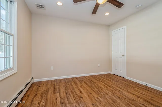 wooden floor in an empty room with a window