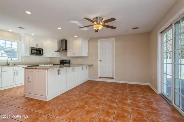 a view of kitchen with cabinets and window
