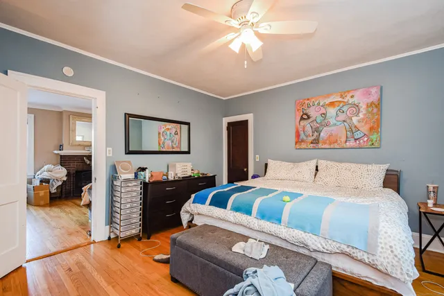 a bedroom with a bed and wooden floor