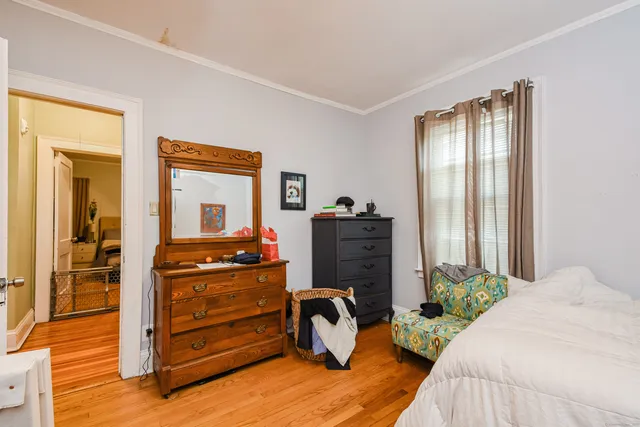 a bedroom with a bed and wooden floor