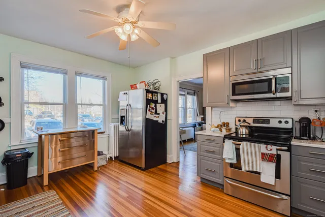a kitchen with stainless steel appliances wooden floors and wooden cabinets