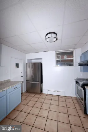a kitchen with granite countertop a stove a sink and a refrigerator