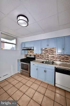a kitchen with granite countertop a sink stainless steel appliances and cabinets