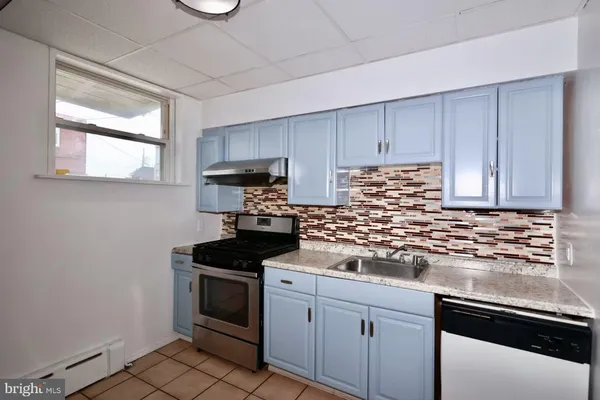 a kitchen with granite countertop white cabinets and stainless steel appliances