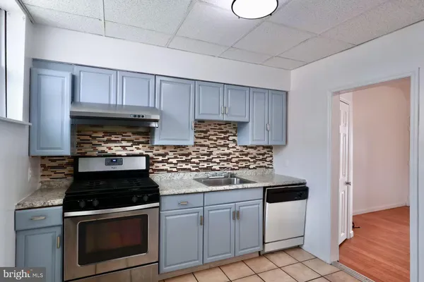 a kitchen with granite countertop a stove sink and cabinets