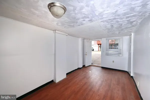 a view of an empty room with wooden floor and cabinet