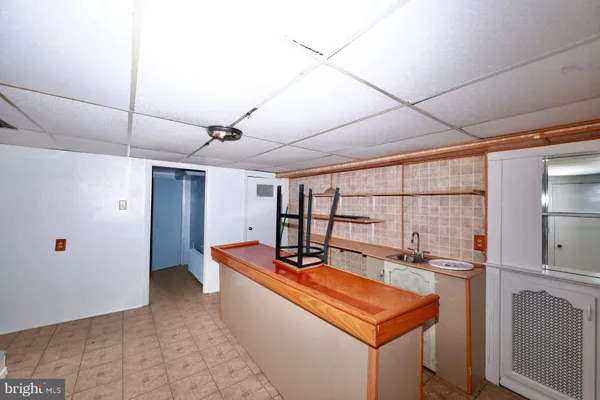 a room with stainless steel appliances kitchen island granite countertop a sink and cabinets