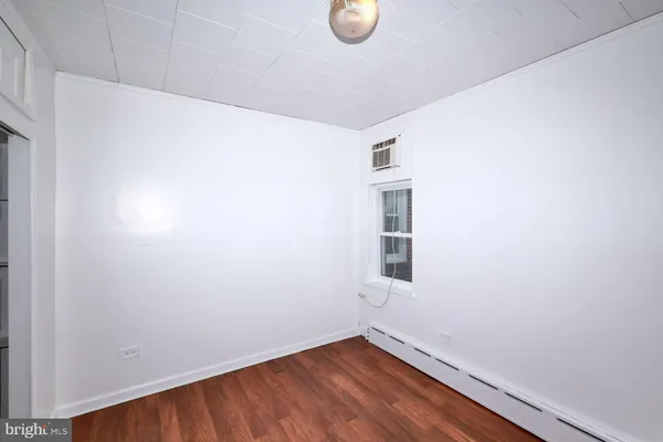 a view of a small space with wooden floor and a window