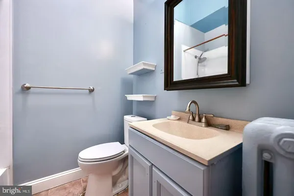 a bathroom with a toilet sink vanity and mirror