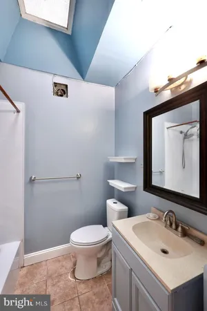 a bathroom with a toilet a sink and mirror