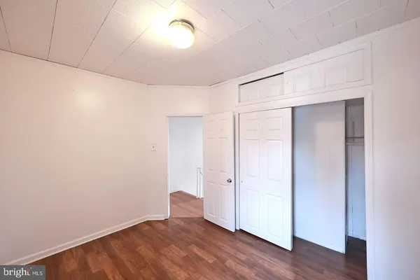 an empty room with wooden floor and closet
