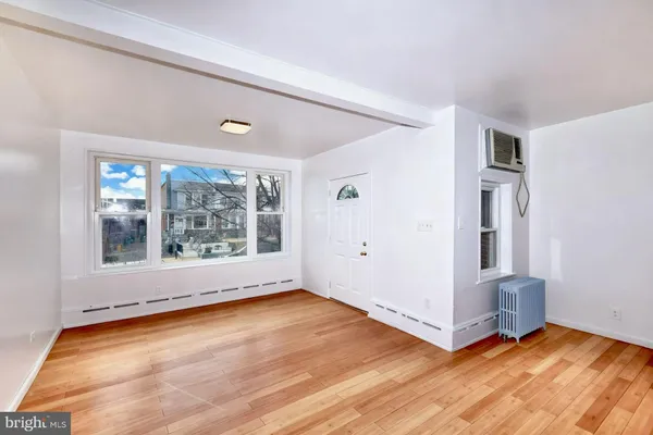 a view of an empty room with glass door and wooden floor