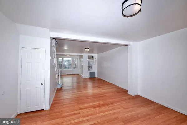 a view of a room with wooden floor and mirror