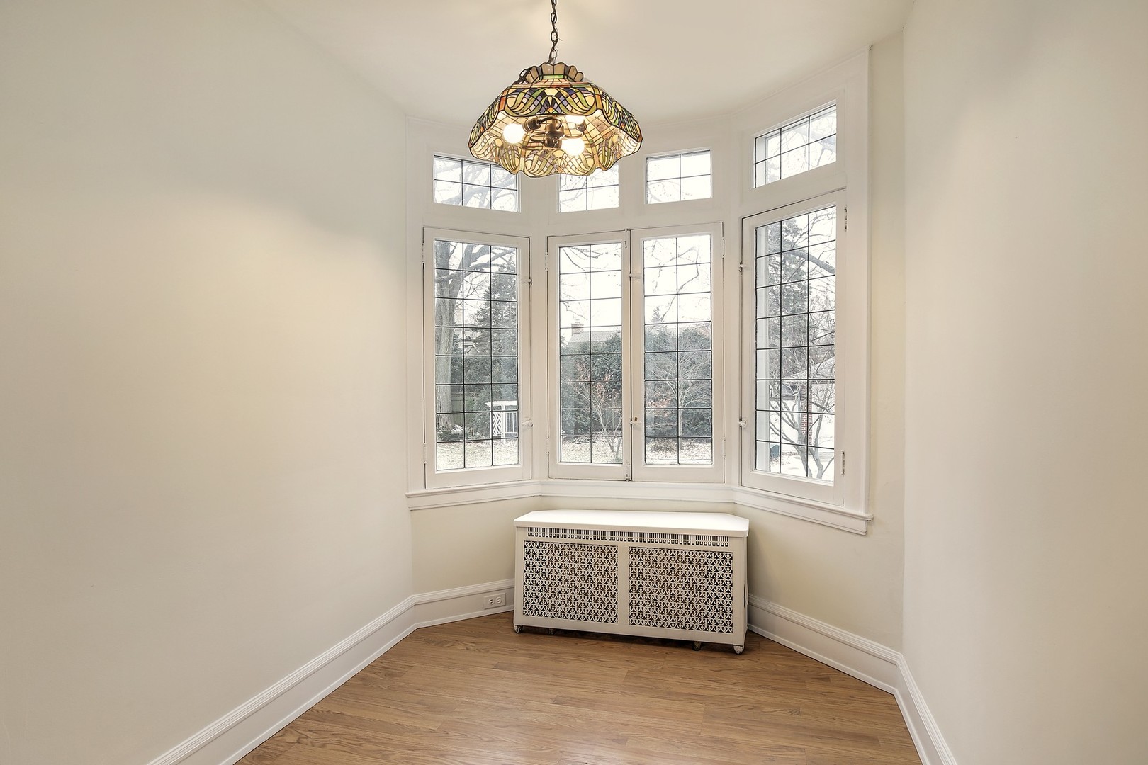 212 Raleigh Road Kenilworth, IL 60043 - Photo 11 of 26 an empty room with wooden floor and windows