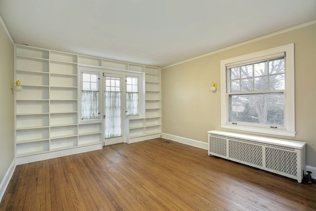 212 Raleigh Road Kenilworth, IL 60043 - Photo 22 of 26 a view of an empty room with a window and wooden floor
