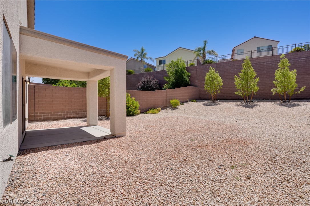 2717 Rimbaud Street Henderson, NV 89044 - Photo 15 of 34 A spacious, rock-covered backyard provides a low-maintenance outdoor living area with a covered patio.