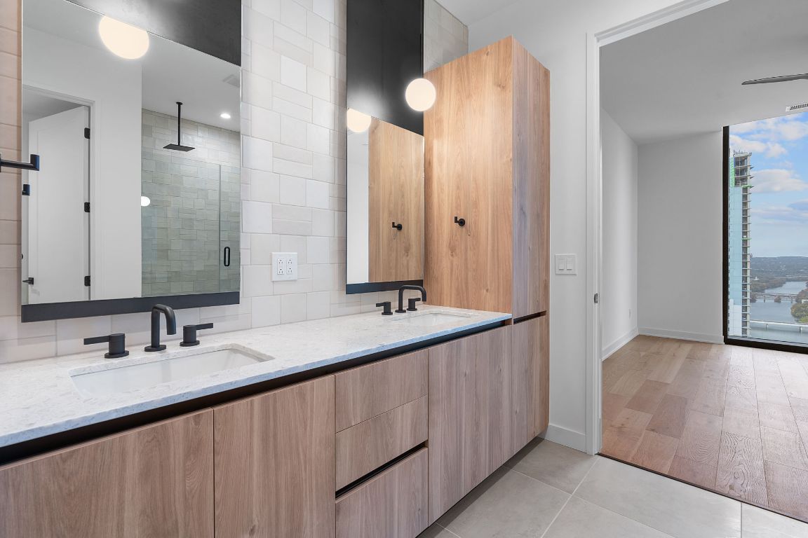 84 East Avenue, Unit 4001 Austin, TX 78701 - Photo 15 of 40 Bathroom with a stall shower, double vanity, light tile patterned flooring, and floor to ceiling windows