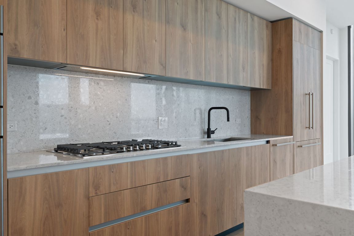 84 East Avenue, Unit 4001 Austin, TX 78701 - Photo 5 of 40 Kitchen featuring modern cabinets, light stone countertops, backsplash, stainless steel gas stovetop, and Italkraft cabinetry