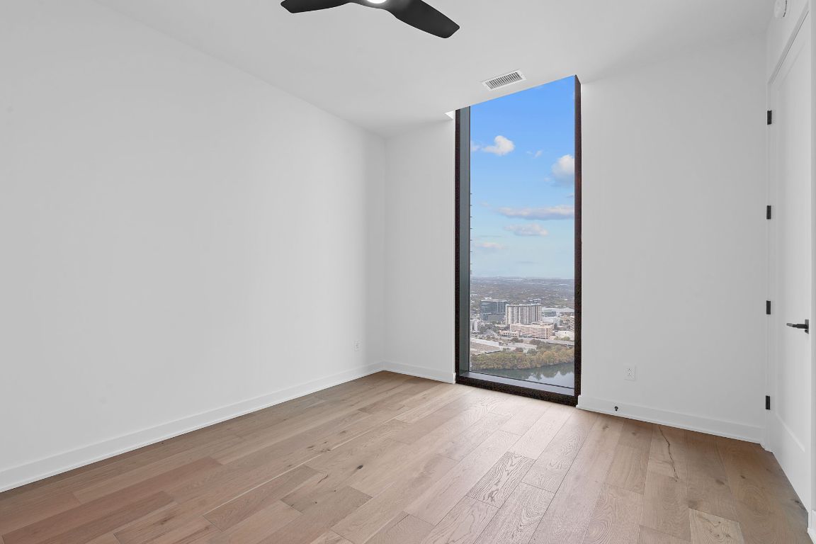 84 East Avenue, Unit 4001 Austin, TX 78701 - Photo 9 of 40 Room with light wood-style floors, expansive windows, a city view, and ceiling fan