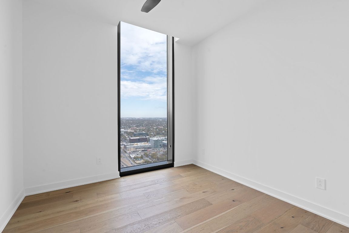 84 East Avenue, Unit 4001 Austin, TX 78701 - Photo 10 of 40 Room with a wall of windows, light wood finished floors, and a city view