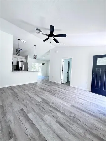 a view of a kitchen with wooden floor and a ceiling fan