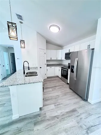 a kitchen with stainless steel appliances granite countertop a refrigerator and a stove top oven