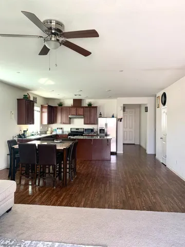 a room with lots of wooden furniture and stainless steel appliances