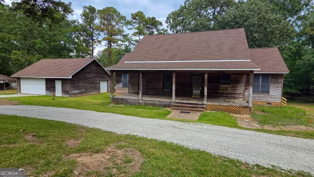 a view of house with a yard and large tree