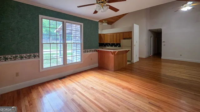a view of an empty room with window and wooden floor