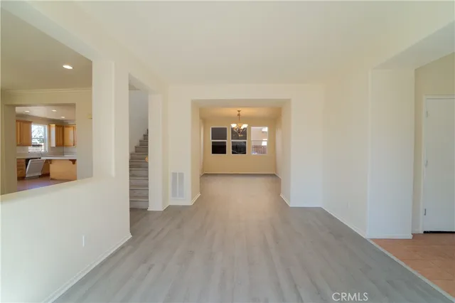 wooden floor in a hall with an entryway and a window