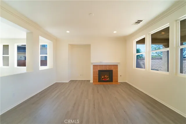 a view of an empty room with a fireplace and a window