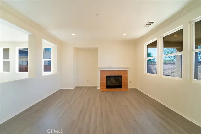 a view of an empty room with a fireplace and a window